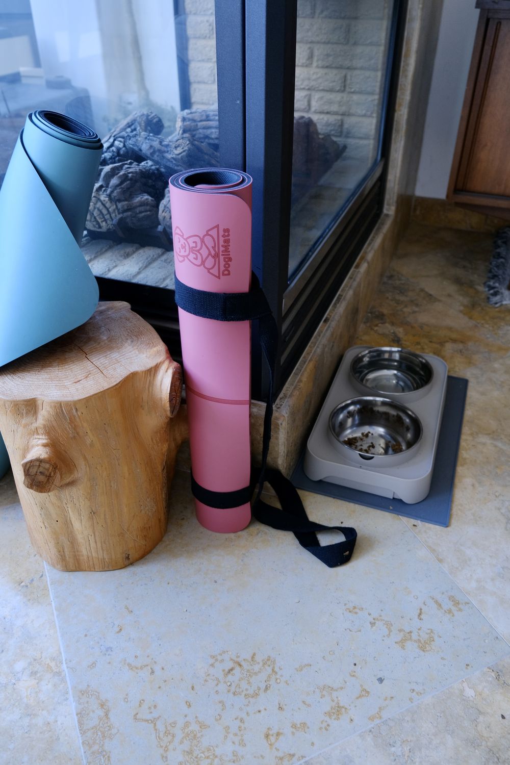 Rolled DogiMats with carry straps by the fireplace